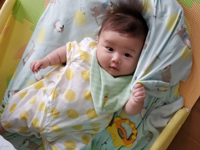 シーツをつかむ赤ちゃん